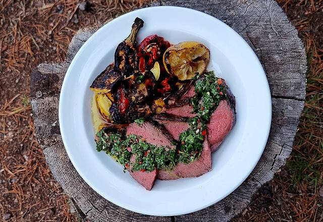 Grillad picanha över öppen eld med chimichurri, spetspaprika och zucchini.